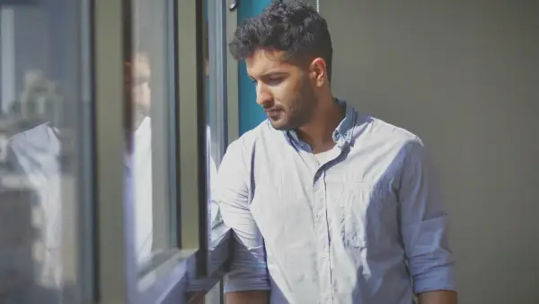 a man looking out the window of a building