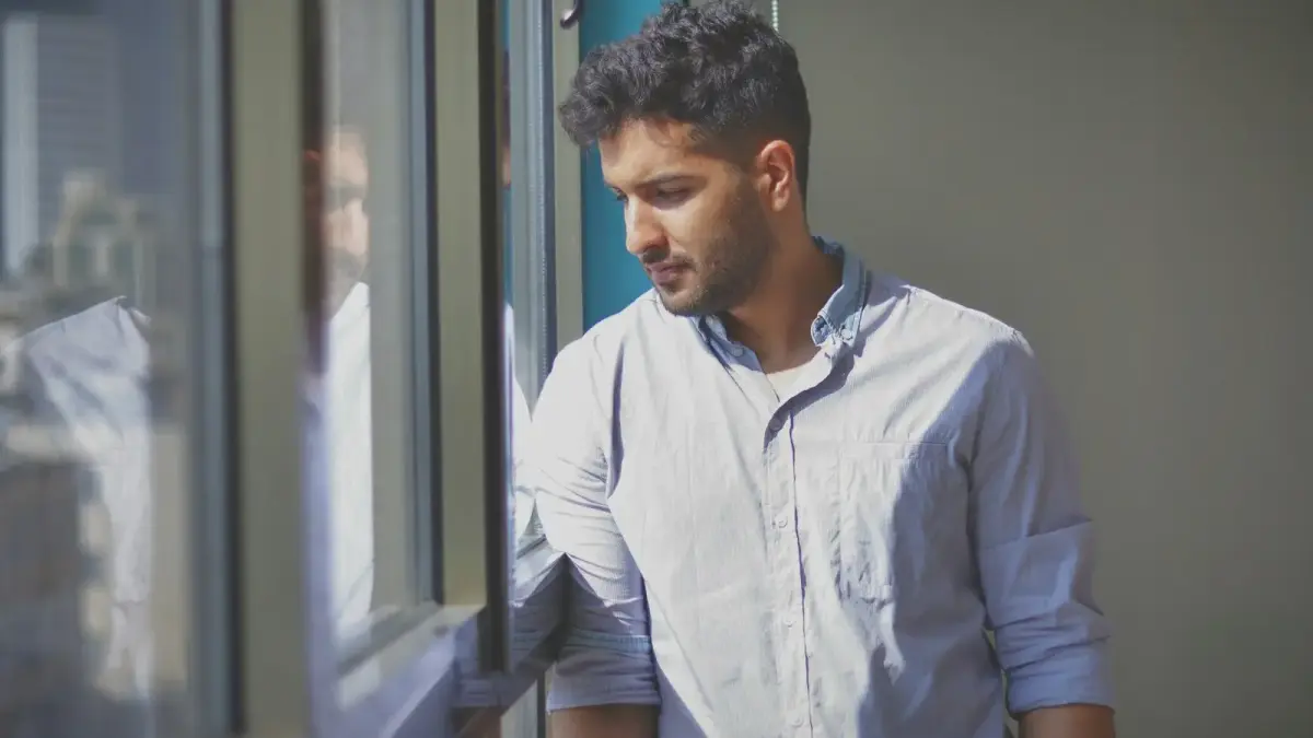 a man looking out the window of a building