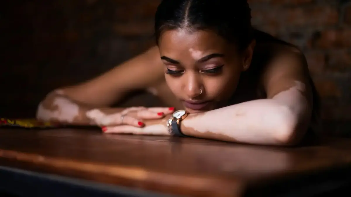 woman in red and white floral dress lying on brown wooden table