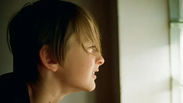 A woman looking out a window at the outside