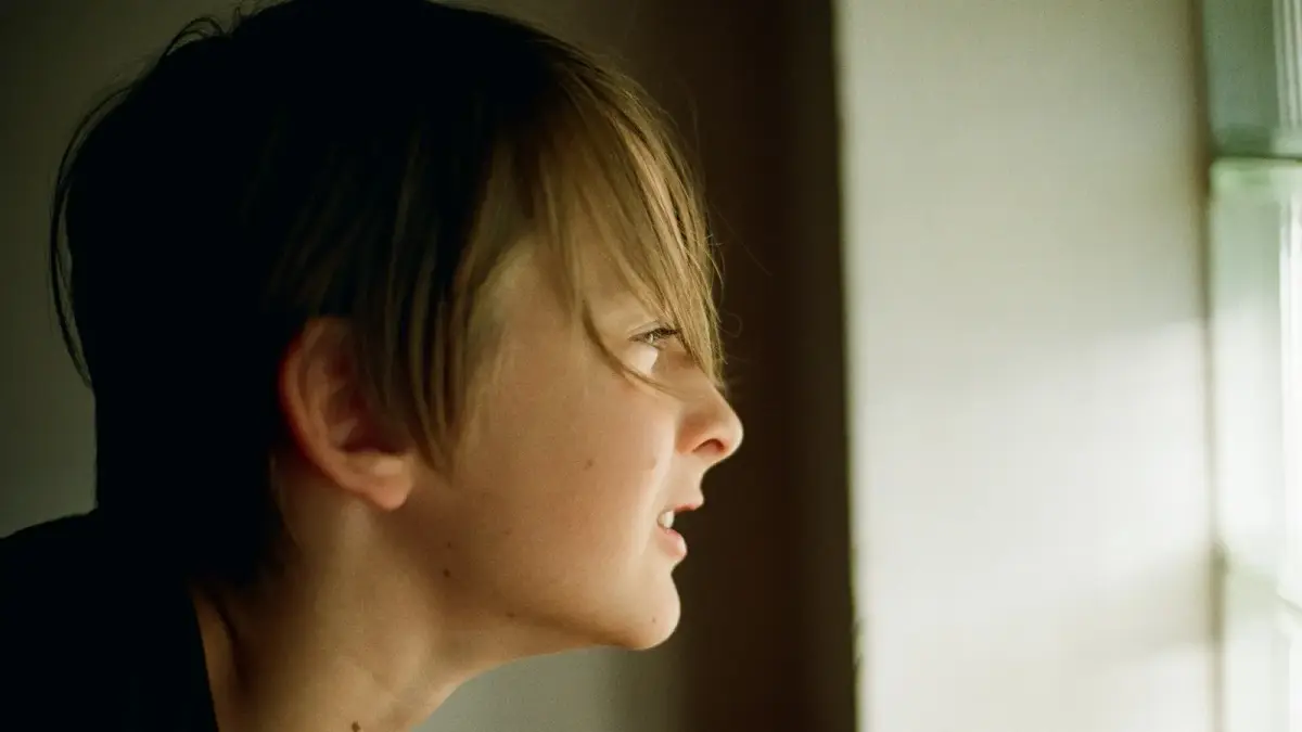 A woman looking out a window at the outside