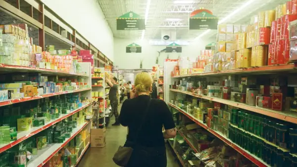 woman in black long sleeve shirt standing near white shelf