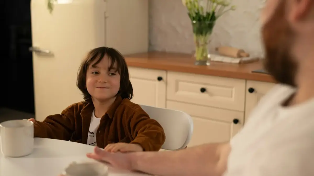 a little girl sitting at a table with a man
