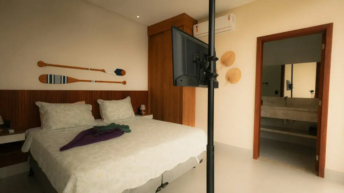 Bedroom with bed, television, and open doorway to bathroom.
