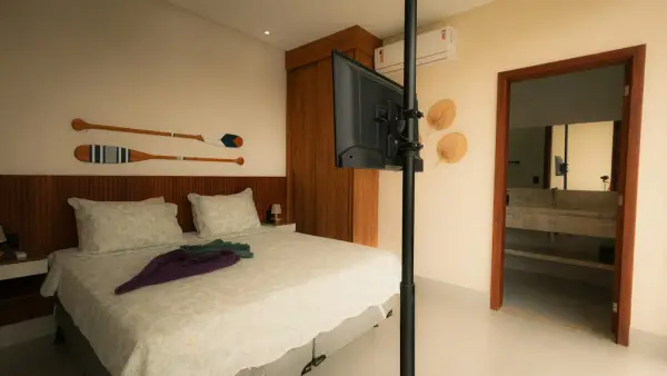 Bedroom with bed, television, and open doorway to bathroom.