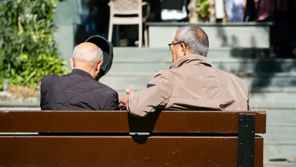 Two elderly men sitting on a park bench