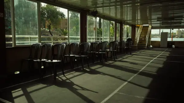 Row of chairs in a sunlit room with long shadows.