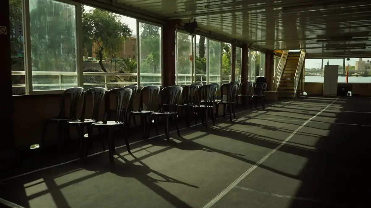 Row of chairs in a sunlit room with long shadows.