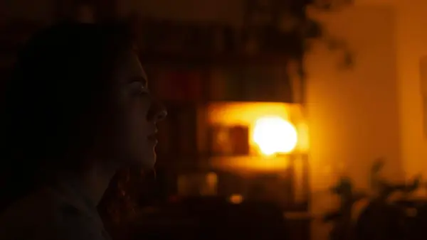 a woman standing in a living room at night