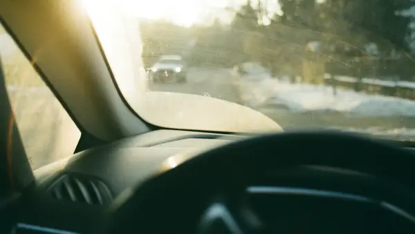 Driving on a snowy road with sun glare