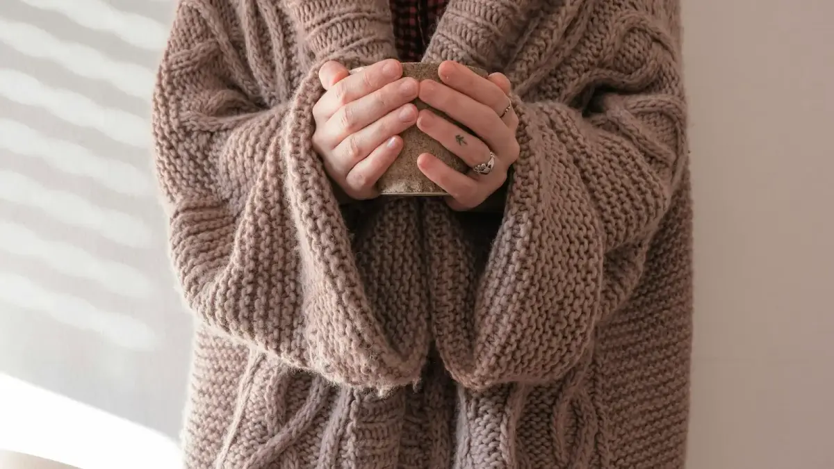 person in brown knit sweater