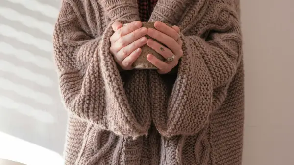 person in brown knit sweater