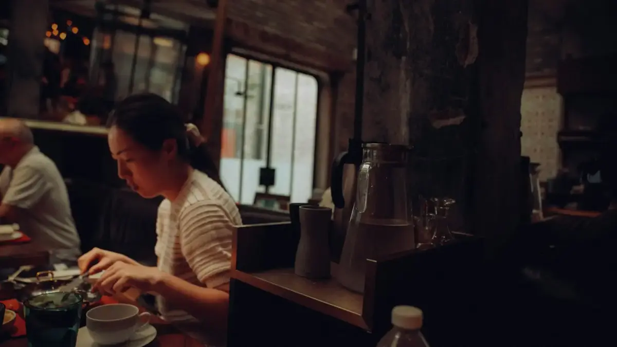 A woman eating in a dimly lit, rustic restaurant