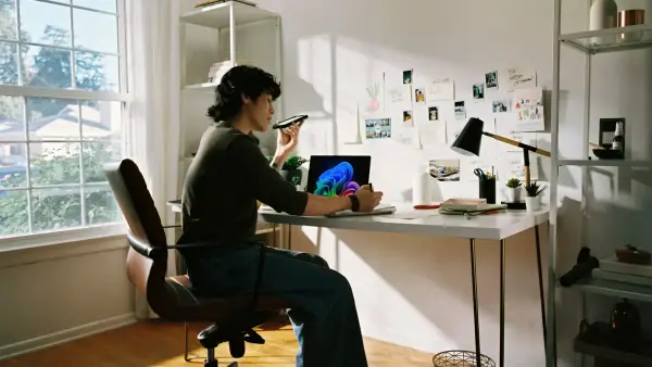 Person working at desk with laptop and phone