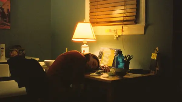 a person sitting at a desk in front of a lamp