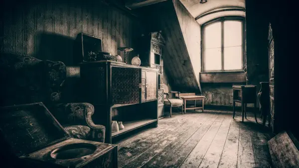 grayscale photo of wooden chair near window