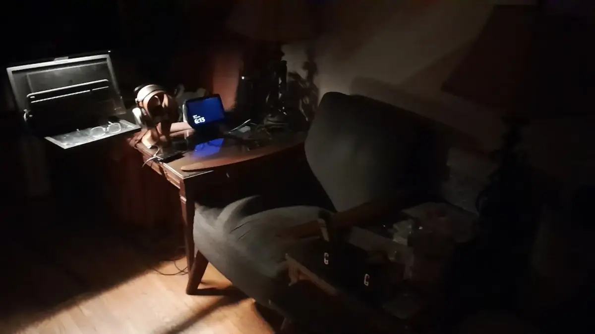 A dimly lit room with a desk and chair