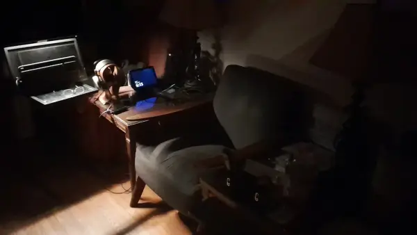 A dimly lit room with a desk and chair