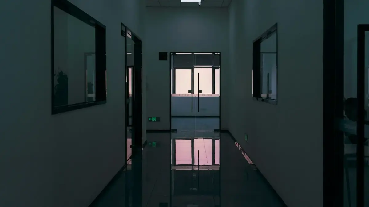Dark, modern hallway with reflective floor and windows