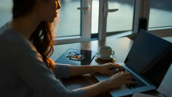 woman sitting beside table using laptop