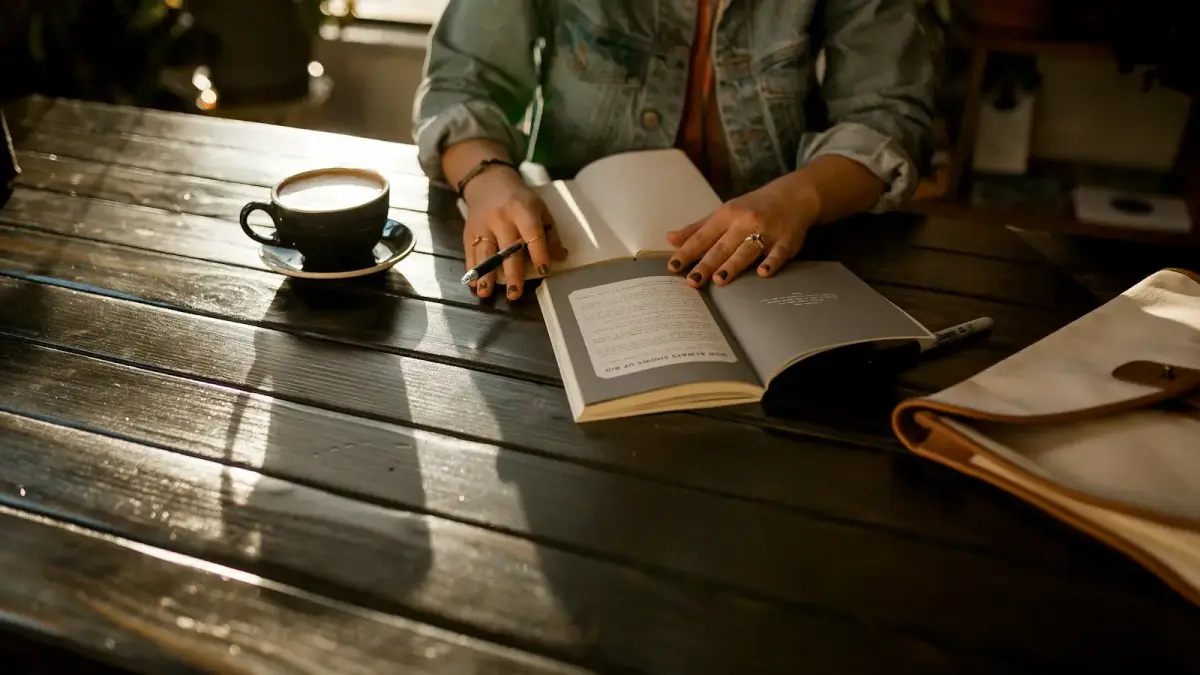 person opening notebook on brown wooden table