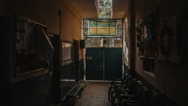 Dimly lit hallway with chairs and doors