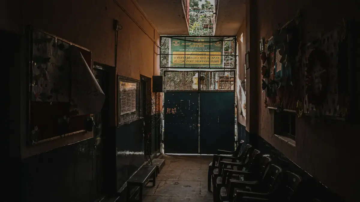 Dimly lit hallway with chairs and doors