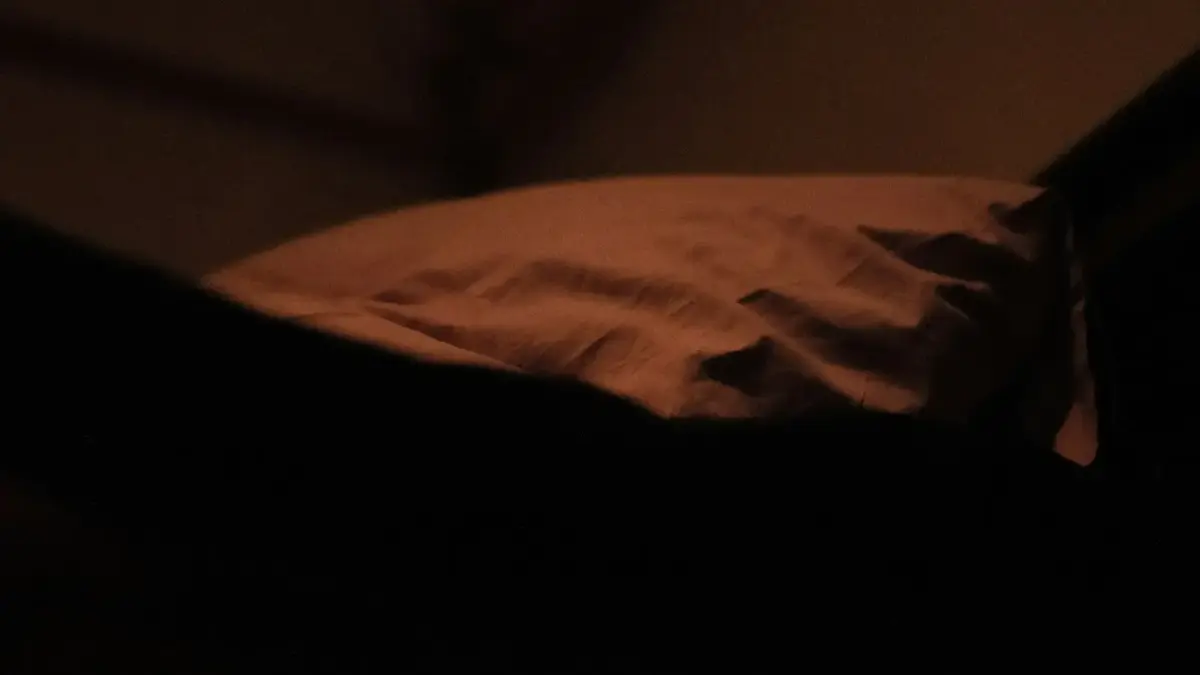 a bed with a white comforter and a black pillow