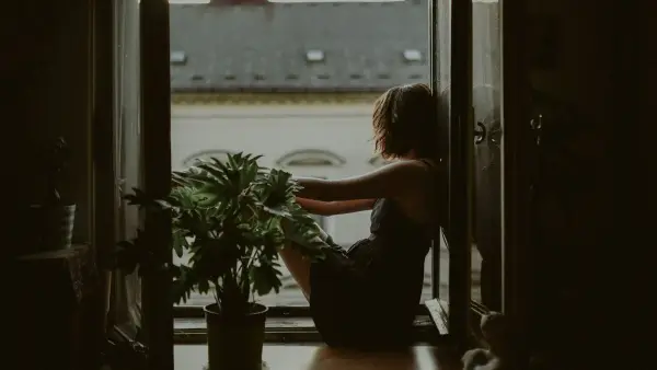 woman leaning on door looking outside