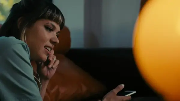 a woman sitting on a couch looking at her cell phone