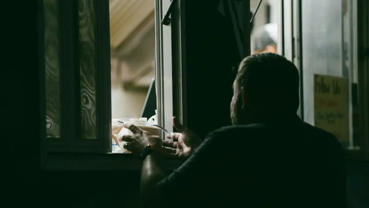 A man receives food through a drive-thru window.
