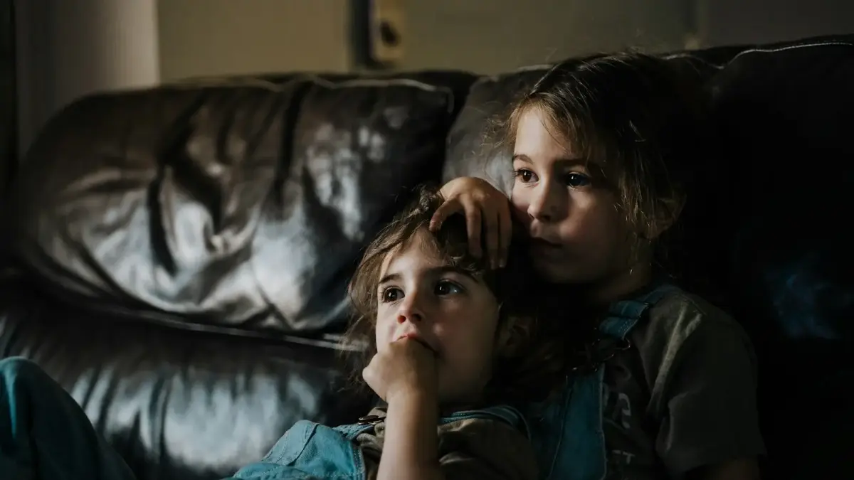 girl in black and gray camouflage shirt lying on black leather couch