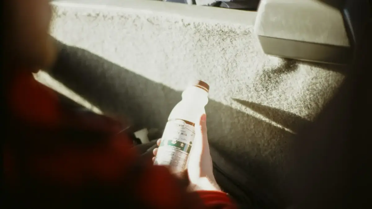 Person holding a bottle in a car