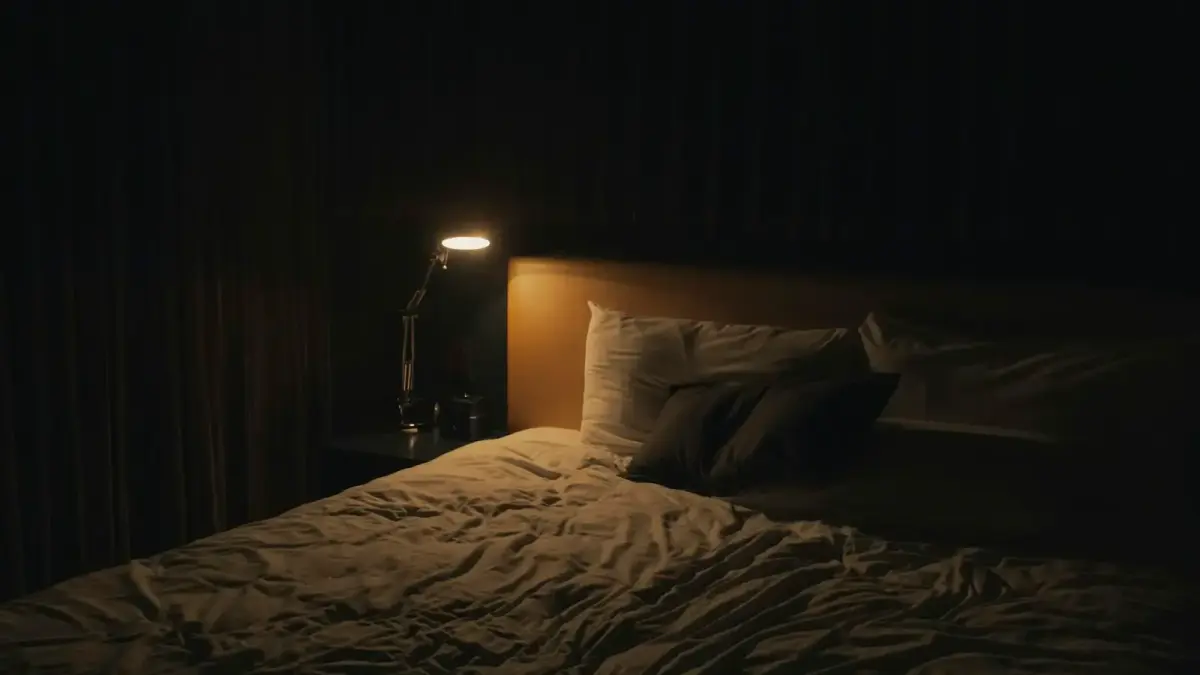 table lamp turned-on near bed