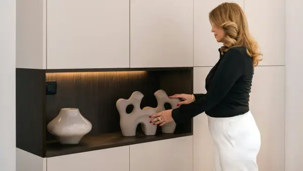 Woman arranging decorative objects on a shelf