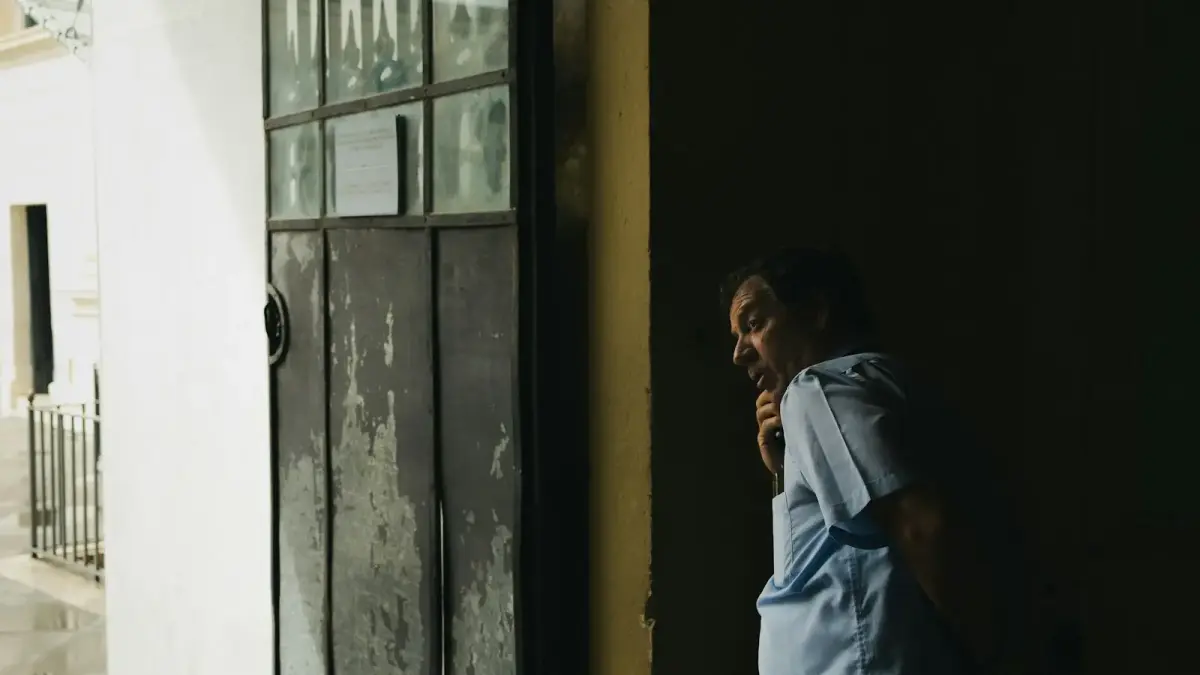 Man standing in doorway with light on his face