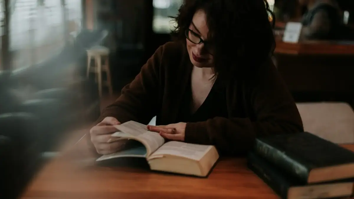 woman in brown long sleeve shirt reading book