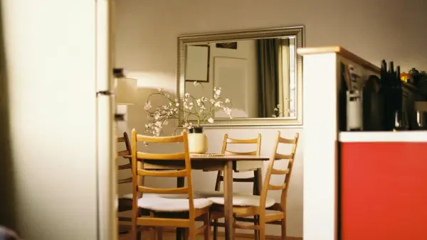 A dining table with four chairs and a refrigerator