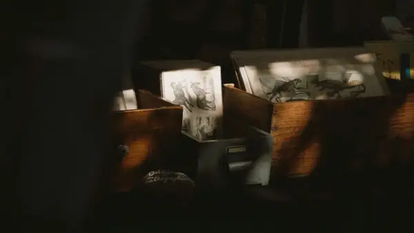 Boxes of drawings sit in the shadows.