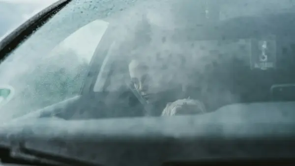 person in black jacket driving car