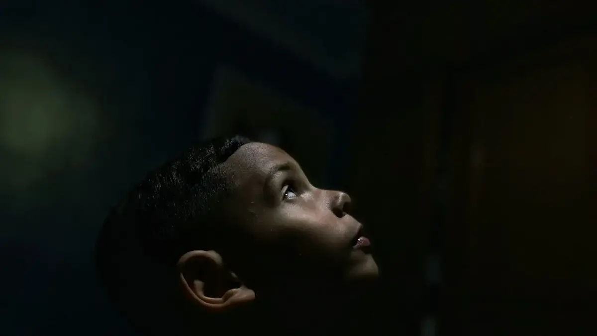 a boy looking up at a light