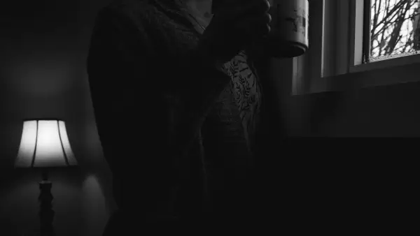 Person holding a mug by a window