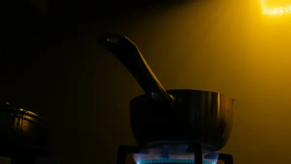A pot on a stove with a blue flame