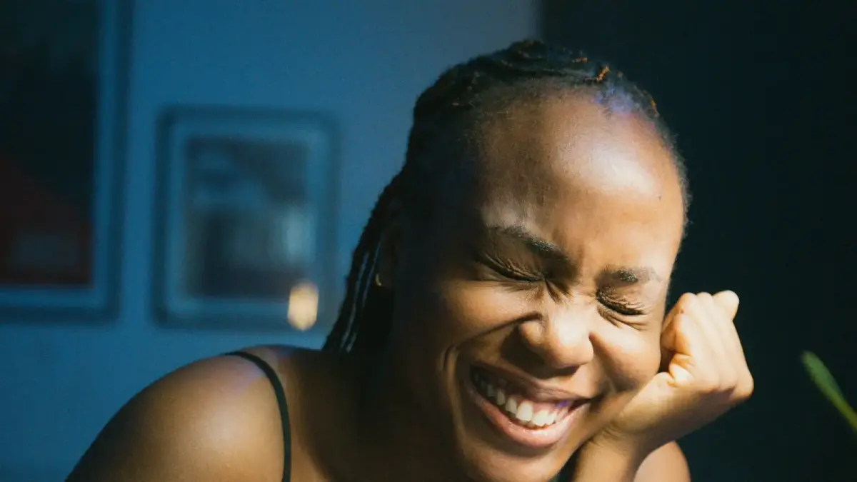 a woman laughing while sitting at a table