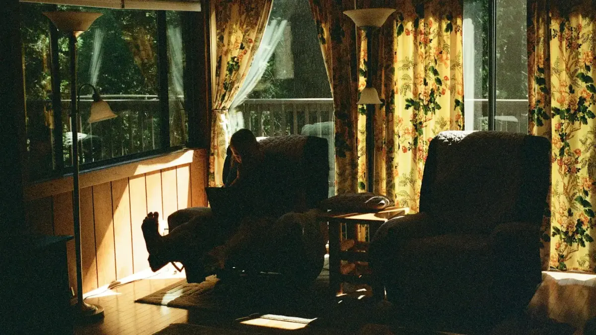 Person relaxing in a recliner by the window.