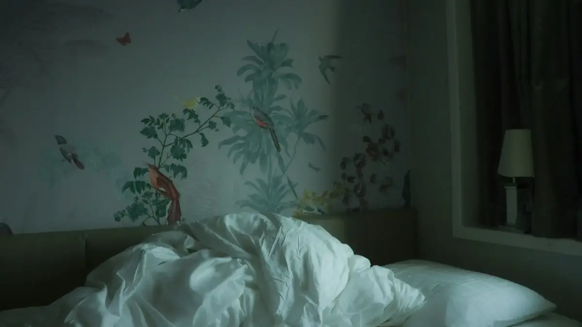 an unmade bed with a white comforter on it
