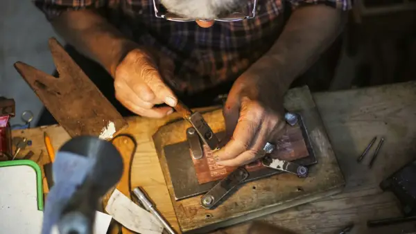 An artisan carefully works on a detailed project