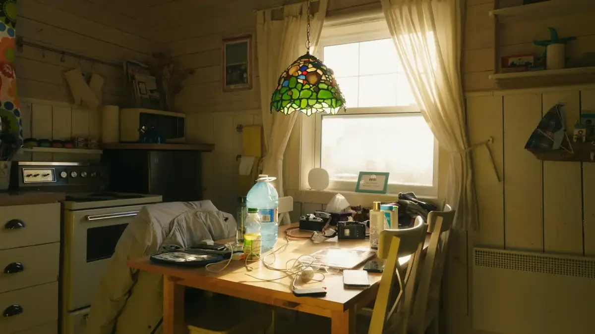 A cluttered kitchen table with a window