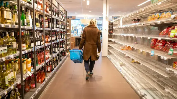 woman in brown coat walking on hallway