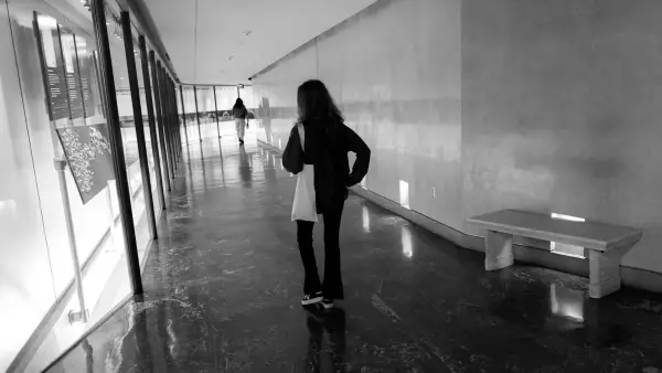 a woman standing in a hallway next to a bench